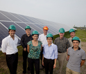 group of people next to solar panels
